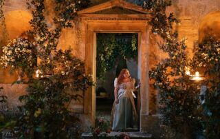 Elegant garden entrance decorated with flowers and ambient lighting for special events.